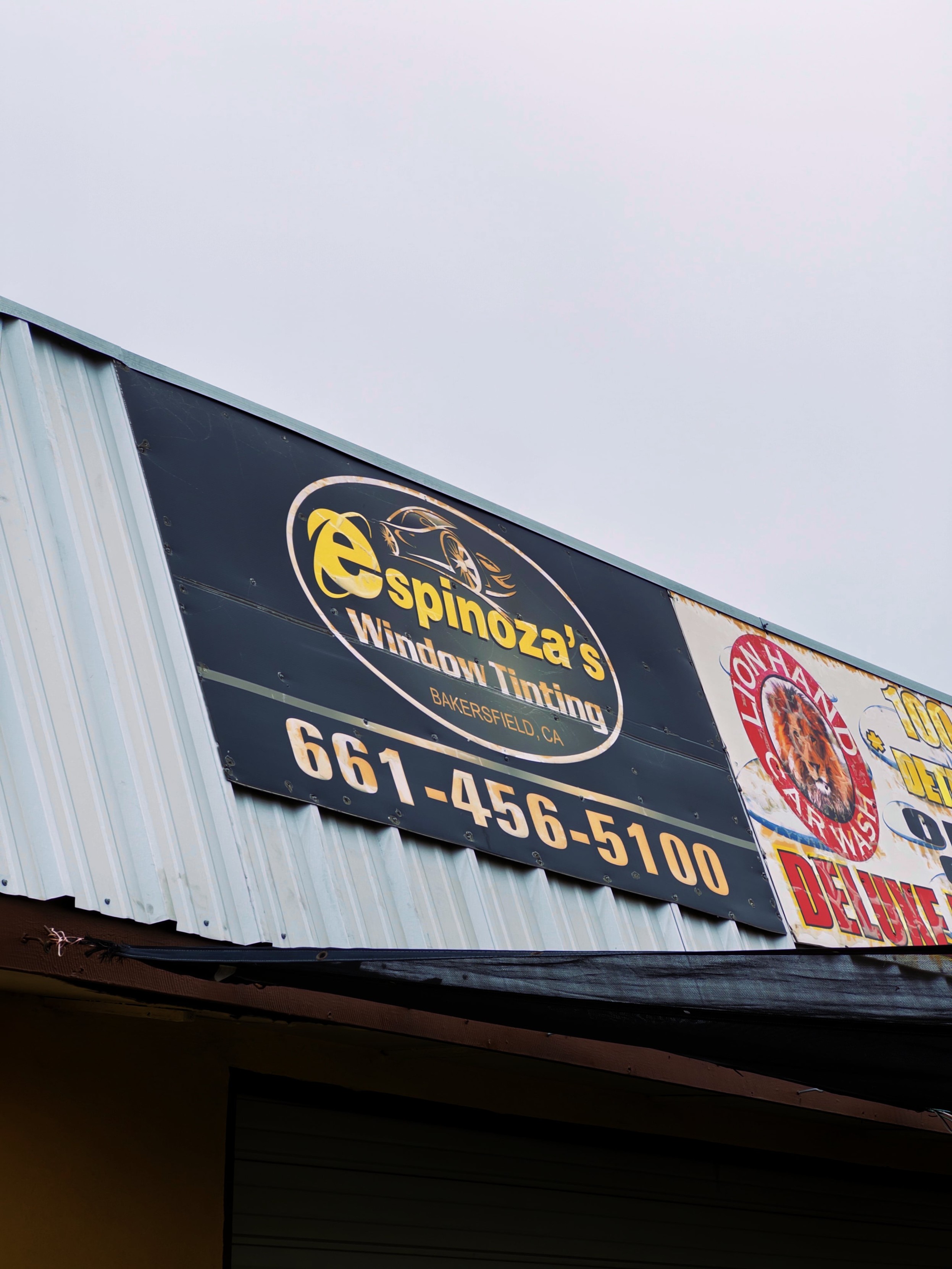 A sign for Espinoza's Window Tinting. The business name is written using the classic Internet Explorer logo as the first letter in Espinoza.